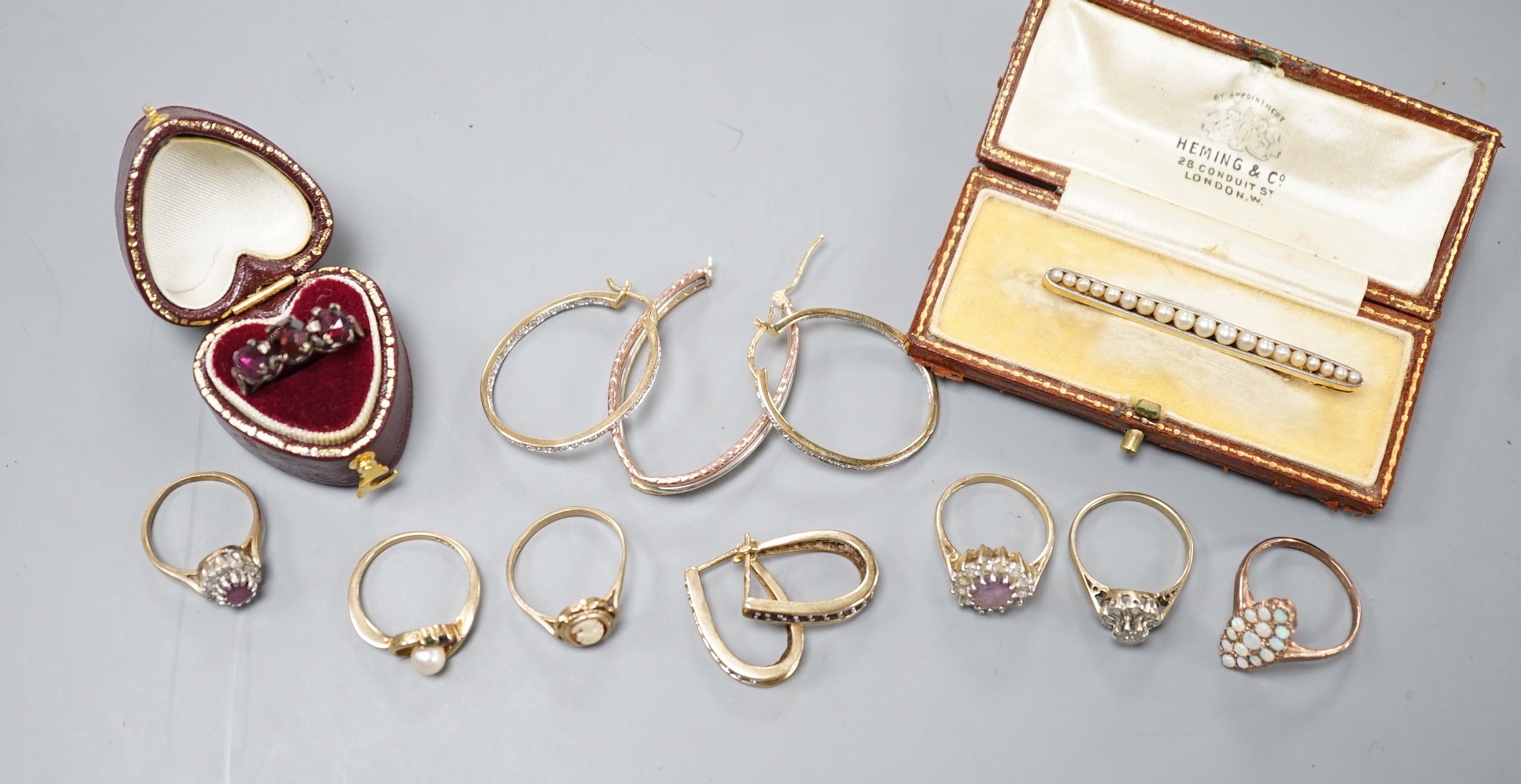 Six assorted modern 9ct gold and gem set rings, including white opal cluster and amethyst and diamond chip, a yellow metal and rose cut three stone garnet set ring, two pairs of modern 9ct gold earrings, including diamon